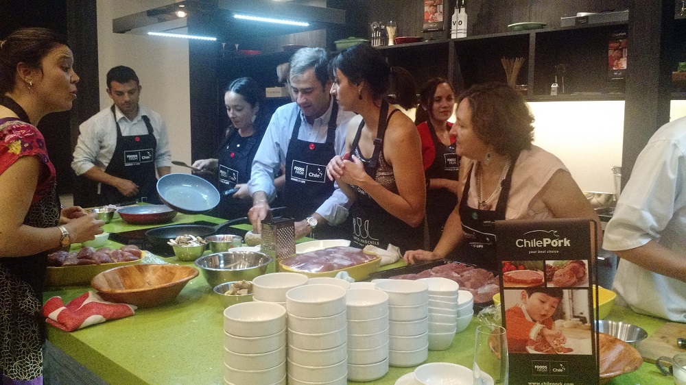 Periodistas y autoridades reunidas en torno a la preparación de solomillo de cerdo al horno y risotto de mote. Todos esforzándose por obtener el primer lugar.
